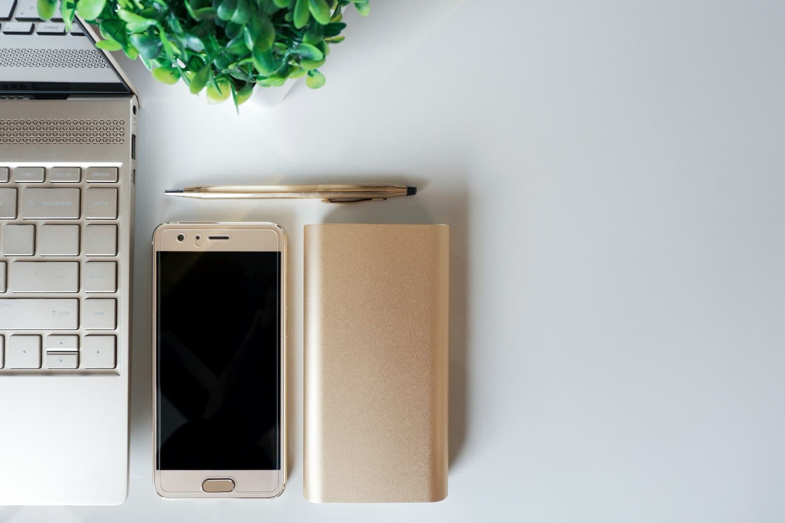 A tidy study workspace with laptop, phone, and notebook.